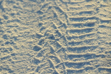 Tire tracks left in the snow on a bright sunny day