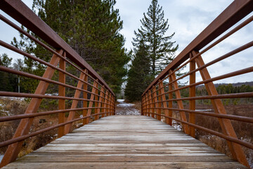 On a wooden footbridge with rusty steel railings
