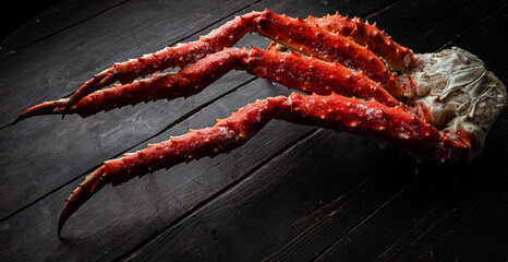 Fresh red king crab crab claws on vintage wooden background. Tasty kamchatka crab's claw © Adsloboda