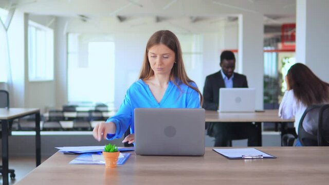 caucasian girl office employee with blond hair working with pc at workplace young businesswoman in casual blue shirt chatting online sitting at desk