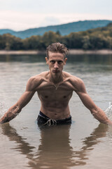 Portrait of a young handsome guy in the water