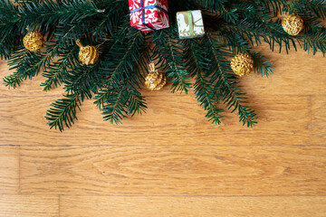 Christmas background with branches of spruce, colorful presents and golden baubles.