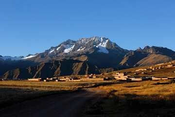 Mount Chicon Behind a Highland Village, Under a Blue Sky. Urubamba Mountain Range, Cusco Region, Peru
