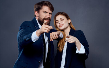 Business man and woman in suit gesturing with hands on gray background cropped view