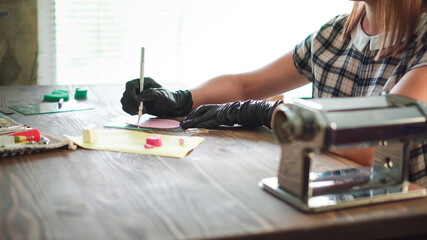 Small business concept. Professional artisan works with polymer clay at workshop.