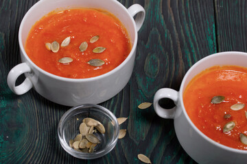 Pumpkin tomato cream soup. With the addition of pumpkin seeds. View from above. On pine boards.