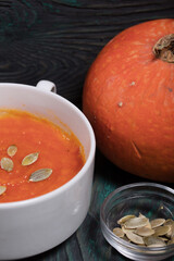  Pumpkin tomato cream soup. With the addition of pumpkin seeds. On pine boards.
