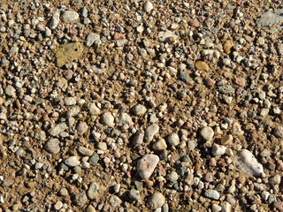 a lot of small stones and gravel on the wet sand