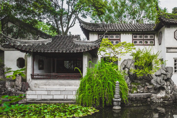 Fototapeta na wymiar Traditional Chinese architecture by pond at Lingering Garden Scenic Area, Suzhou, Jiangsu, China