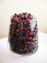 glass full of pomegranate seeds on white background, still life food juicy red pomegranate seeds rich in vitamins and antioxidants