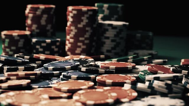 Vintage close-up of poker chips which are at stake lying on a green table. Equipment for hazard games in casino. Winning and losing money theme. Concept of gambling as entertainment at leisure time