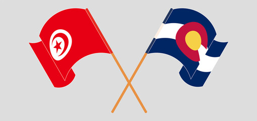 Crossed and waving flags of Tunisia and The State of Colorado