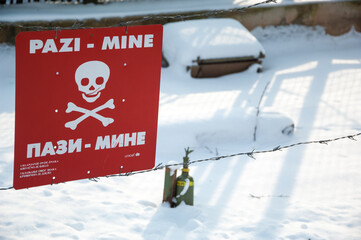 Landmines sign, danger minefield with mines and projectiles in the background