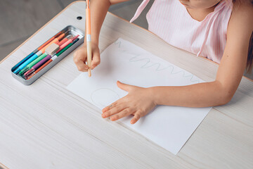 Top view of a drawing of a little girl in a dress. Drawing with crayons. Children's creativity concept. photo with noise.