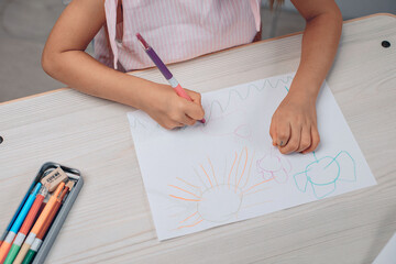 Top view of a drawing of a little talanted girl in a dress. Drawing with crayons. Drawing hobby concept. photo with noise