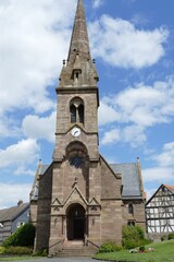 Fototapeta premium Kirche mit Fachwerkhäusern in Seigertshausen / Knüll