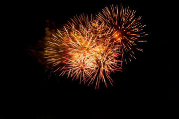 Orange blurred firework lights on black sky background. Concept of New Year and Christmas. Victory salute for Independence Day.