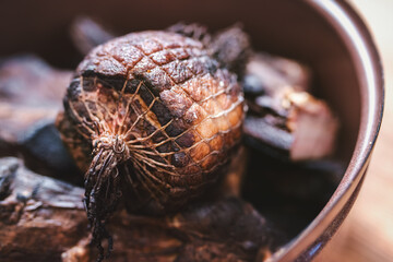 Shallow depth of field shot of pieces of smoked pork in a pot.