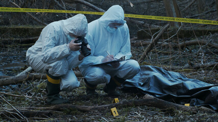 Detectives are collecting evidence in a crime scene. Forensic specialists are making expertise....