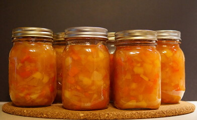 Close-up of jars of homemade fruit ketchup on a black background