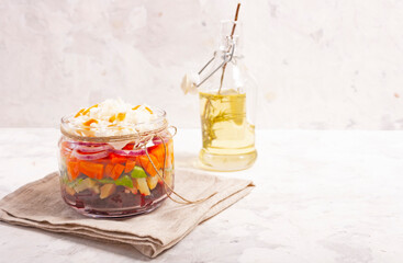 Boiled vegetable salad: beets, carrots, potatoes, sauerkraut, herbs, sunflower oil in a glass jar...