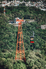 Fototapeta premium Cable car on a cableway (teleferico) over the city and green mountain in Puerto Plata, Dominican Republic