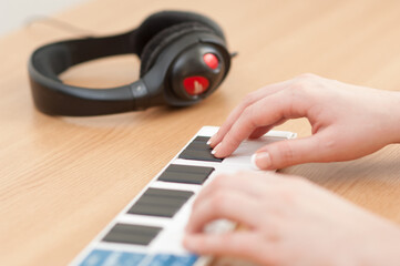 Close up of hands playing on a Korg nanoKEY MIDI controller keyboard