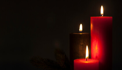 Lighted candles. Defocused Lights garlands in the background. On a dark background. Christmas card.