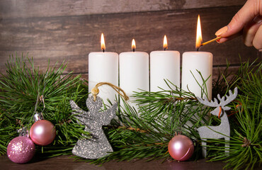 advent wreath for christmas, girl lights fourth candle