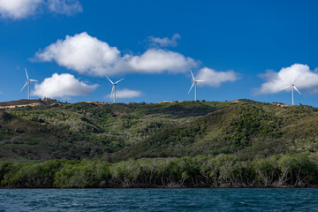 Panoramic view on the windmills on the mountain with cloudy sky and blue water of Atlantic Ocean,...