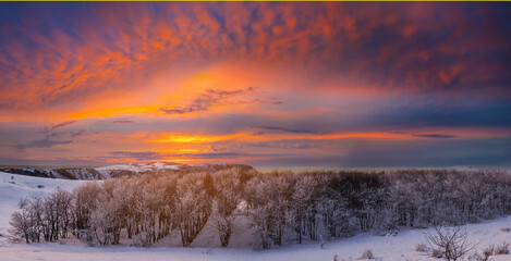 winter snowbound forest at the dramatic sunset, natural season background