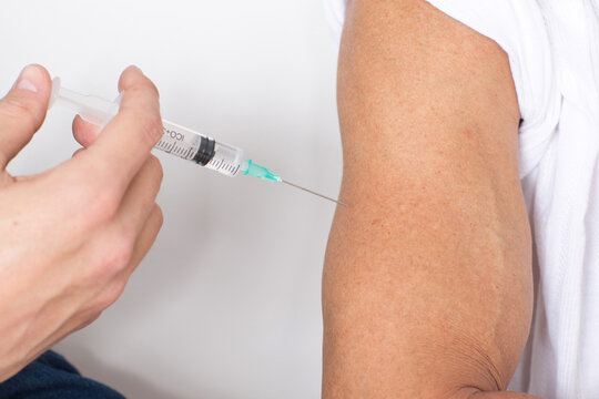 Close-up of syringe injection in upper arm, vaccination and healthcare concept