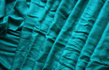 Textured turquoise cloth with folds. Woven background. Pattern.