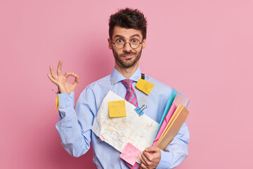 Unshaven student shows okay gesture dressed in formal shirt and tie satisfied with exam result...