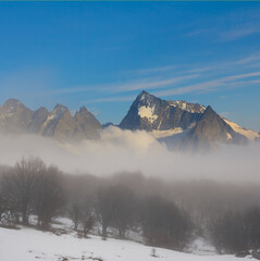 winter mountain valley in a dense clouds and mist, winter travel background