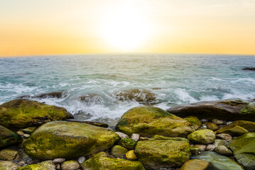 Fototapeta na wymiar sea coast with stones at the sunset, natural sea background