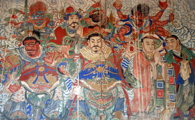 Yungang Grottoes near Datong in Shanxi Province, China. Colorful fresco in a cave at Yungang with characters from history and legend. Yungang Buddhist cave art and sculptures UNESCO world heritage.