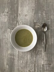 A bowl of homemade broccoli soup on a wooden background 