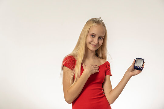 Teenage girl with blond hair in red dress holds a diamond box with diamonds
