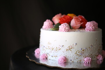 Luxury wedding table with a beautiful pink cake decorated with mastic pink rose and gold on black background