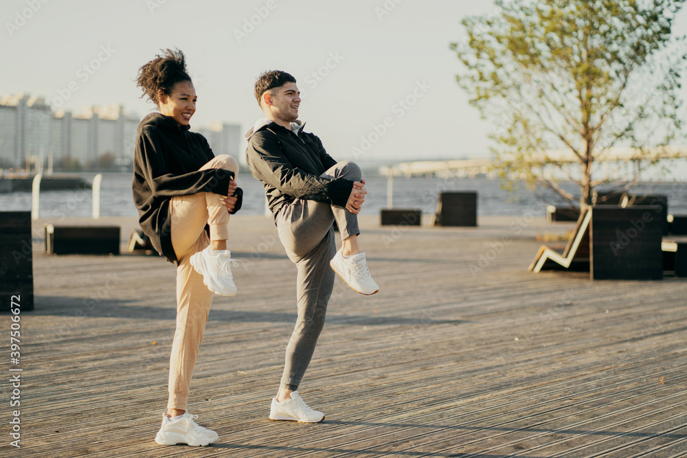 Wall mural do stretching exercises in the city two athletes a woman and a man. young sports couple friends are 