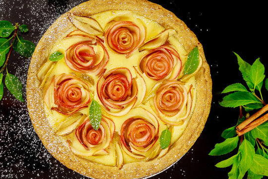 Close uo of apple pie with rose shape apple decorated and fresh apples.