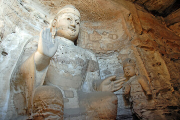 Yungang Grottoes near Datong in Shanxi Province, China. Large ancient statue of Buddha in a cave at...