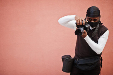 Young professional african american videographer holding professional camera with pro equipment....