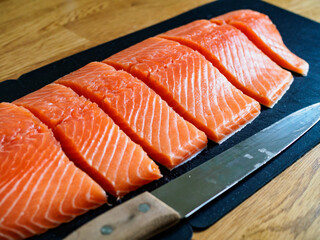 Fresh raw salmon steaks with salt on wooden board
