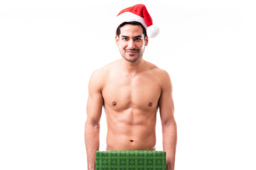 Confident naked man with a Christmas present