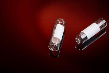 group of used medical ampoules over dark red background. copy space. vaccination concept