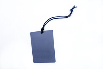 Empty paper tag tied with black string. Price tag, gift tag, sale tag on the blue background, close up