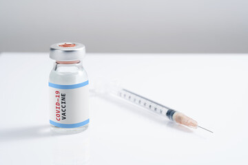 Covid-19 Written vaccine bottle with a syringe on a white background