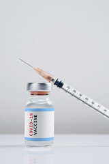 Covid-19 Written vaccine bottle with a syringe on a white background